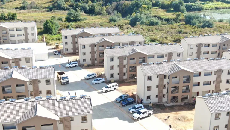 Completed three-storey apartment blocks with parked cars at Affri-Village Greenhills