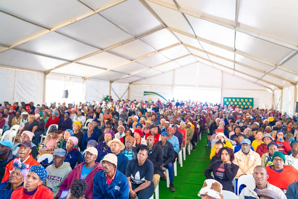 Residents seated in a marquee at the Greenhills title deed handover