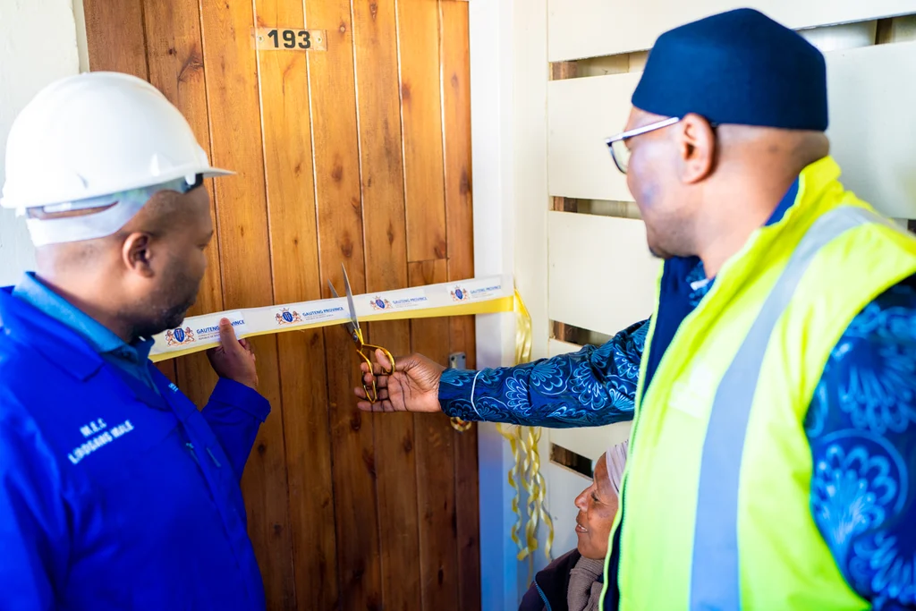 Two officials at the front door of a new home at Affri-Village Greenhills